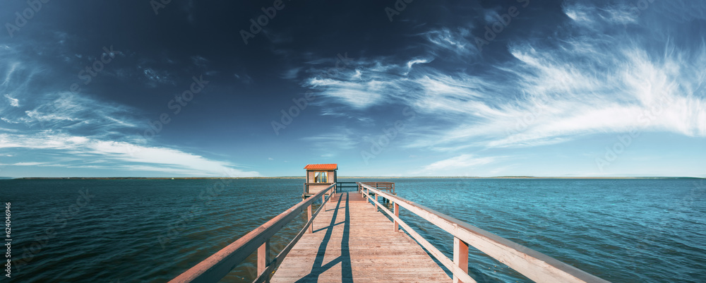 Old Wooden Pier For Fishing, Small House Shed And Beautiful Lake Or River In Background. Picturesque