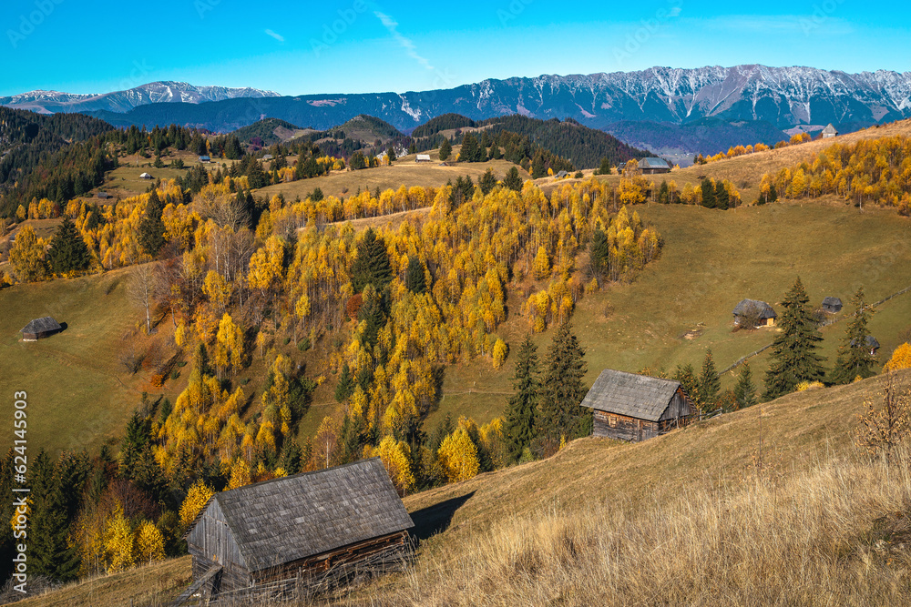 Autumn countryside landscape with wooden huts on the hills, Romania