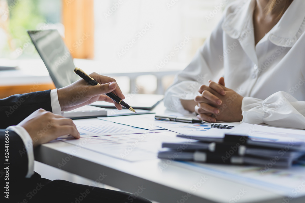 Financial advisor discussing business management planning with businesswoman in office.