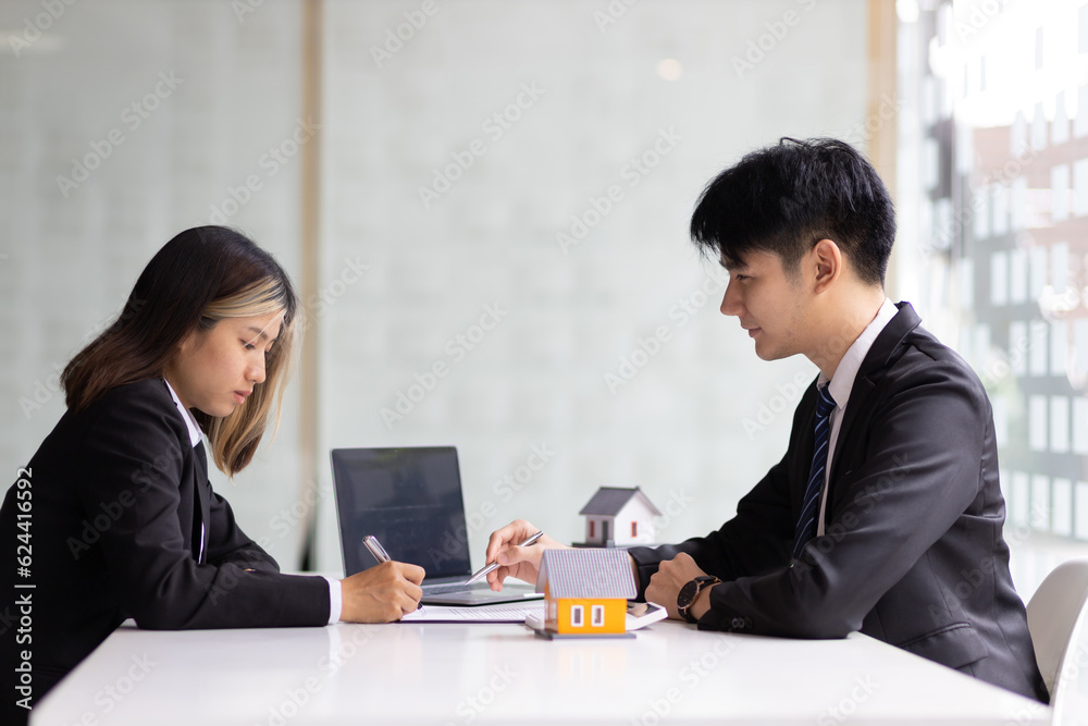 Real estate agent holding pen pointing at contract document for client to sign home purchase agreeme