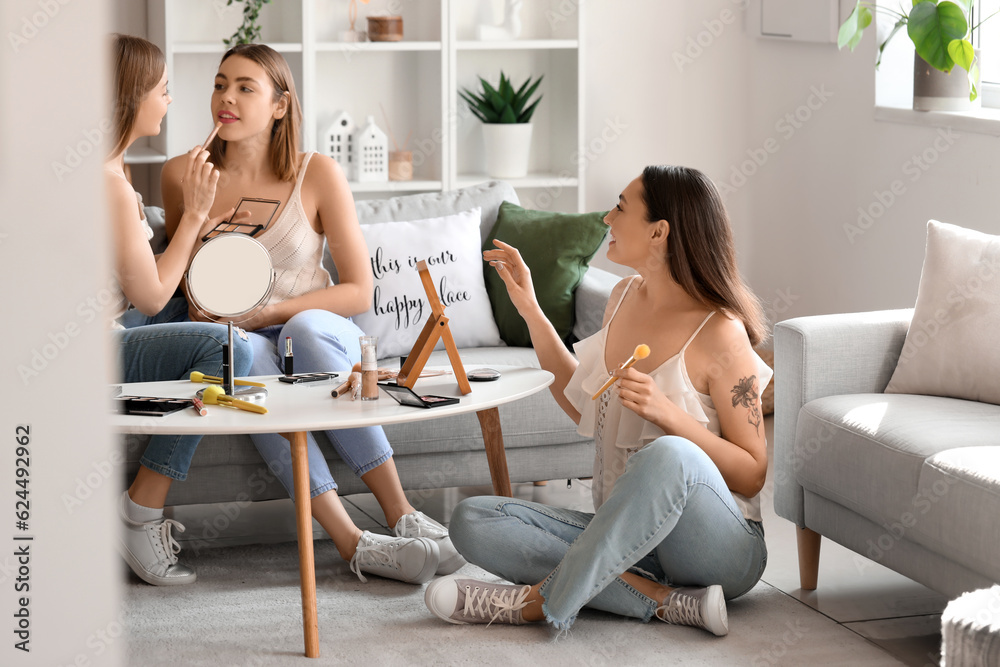 Young women doing makeup at home