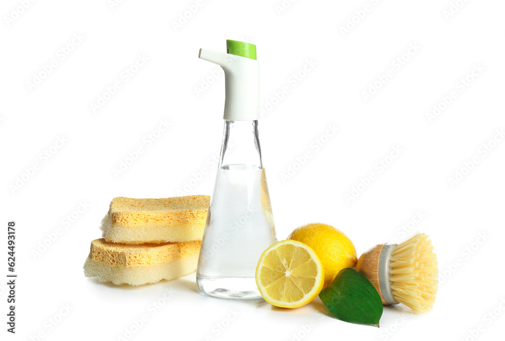 Bottle of vinegar, sponges, brush and lemons on white background