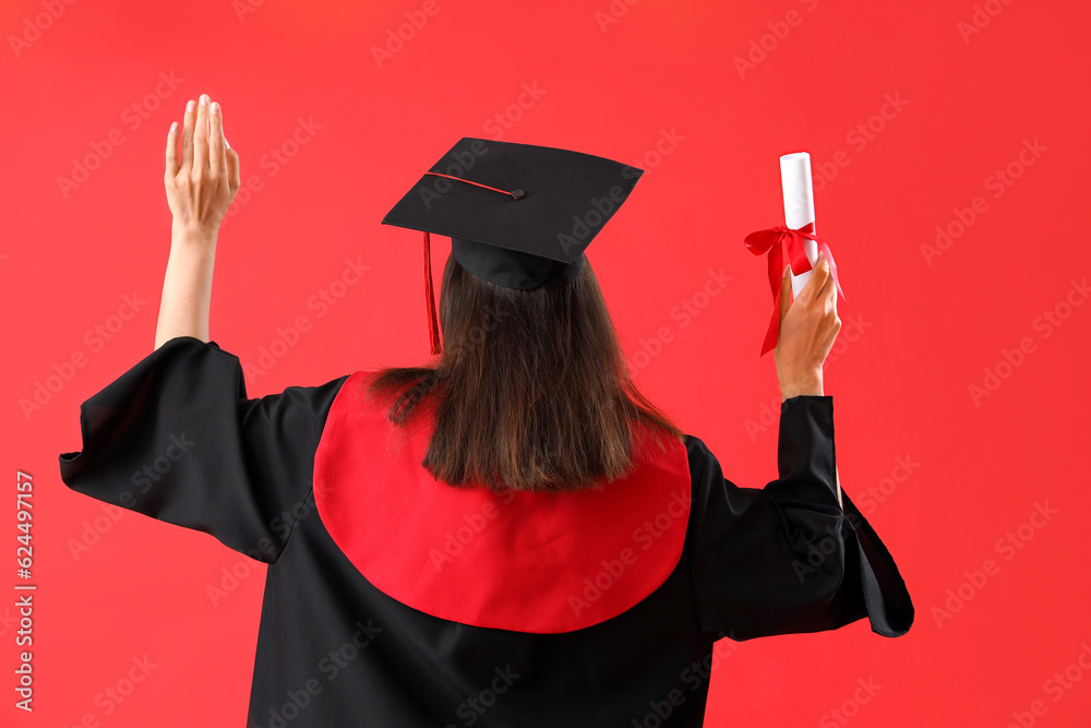 Female graduate student with diploma on red background, back view