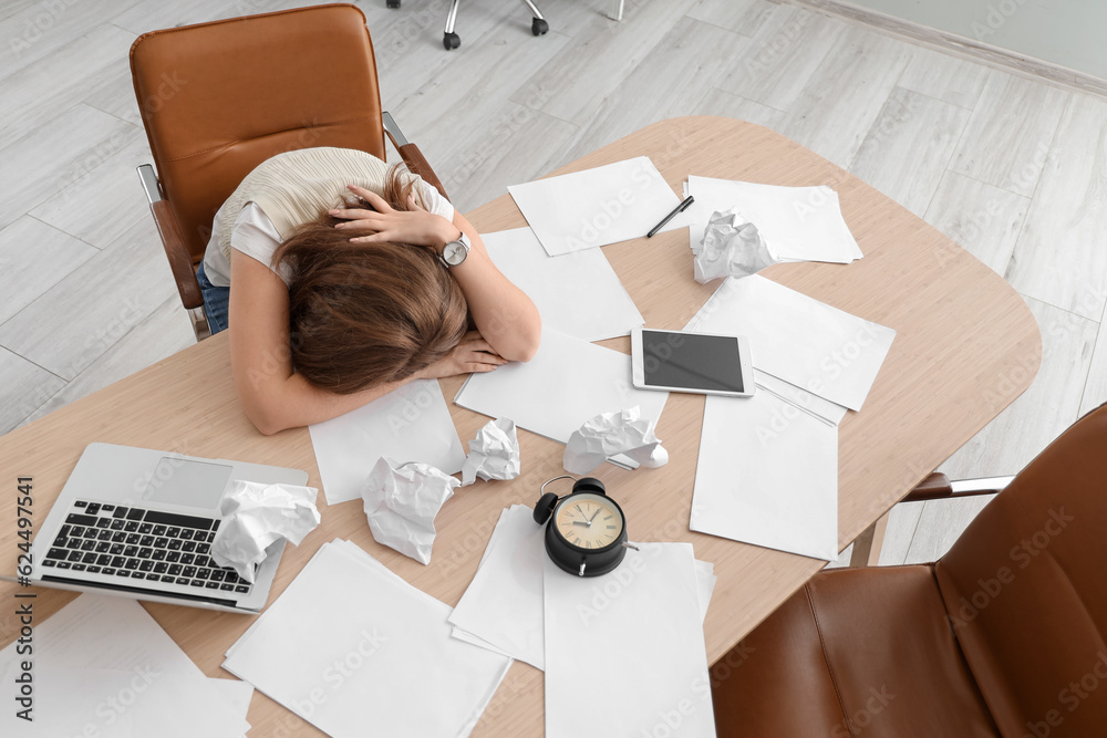 Stressed young businesswoman working under deadline in office