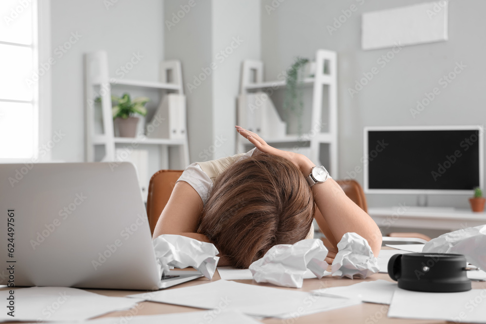 Stressed young businesswoman working under deadline in office