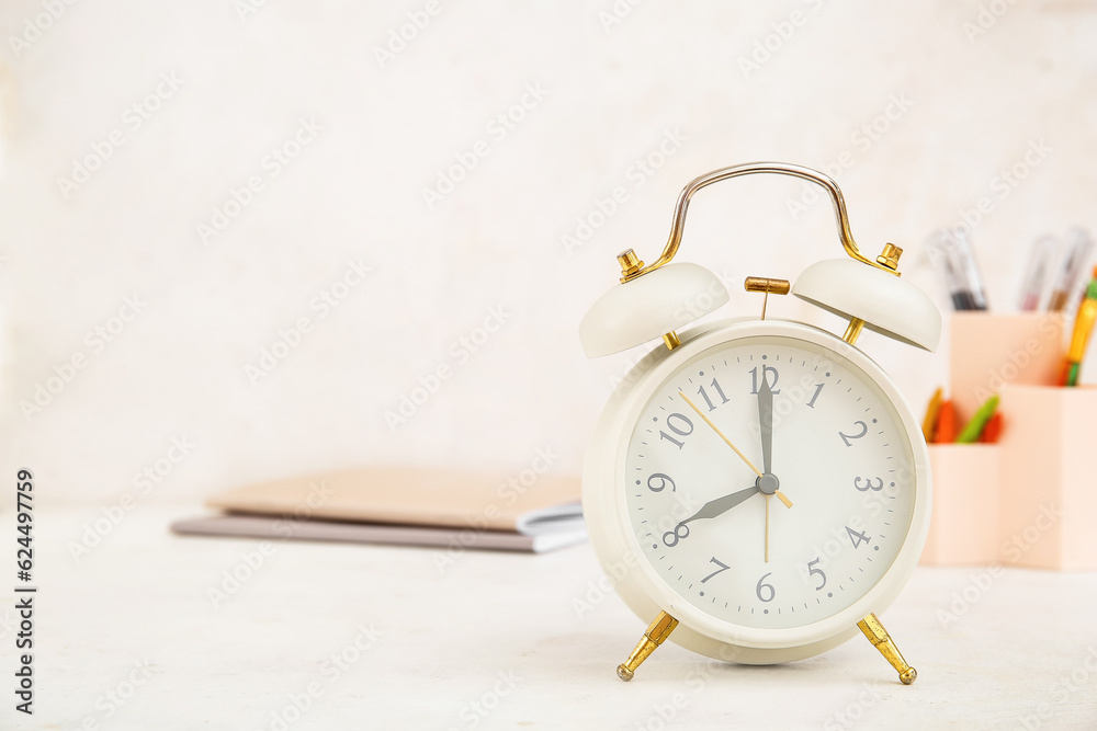 Alarm clock with different stationery on white table