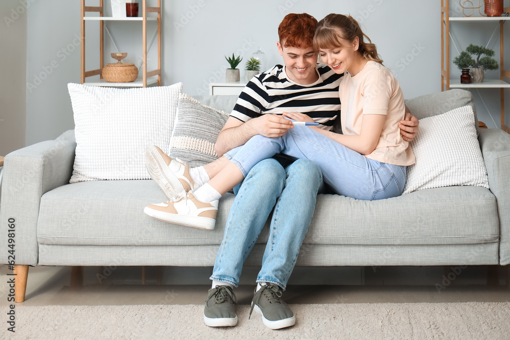 Happy young couple with pregnancy test at home