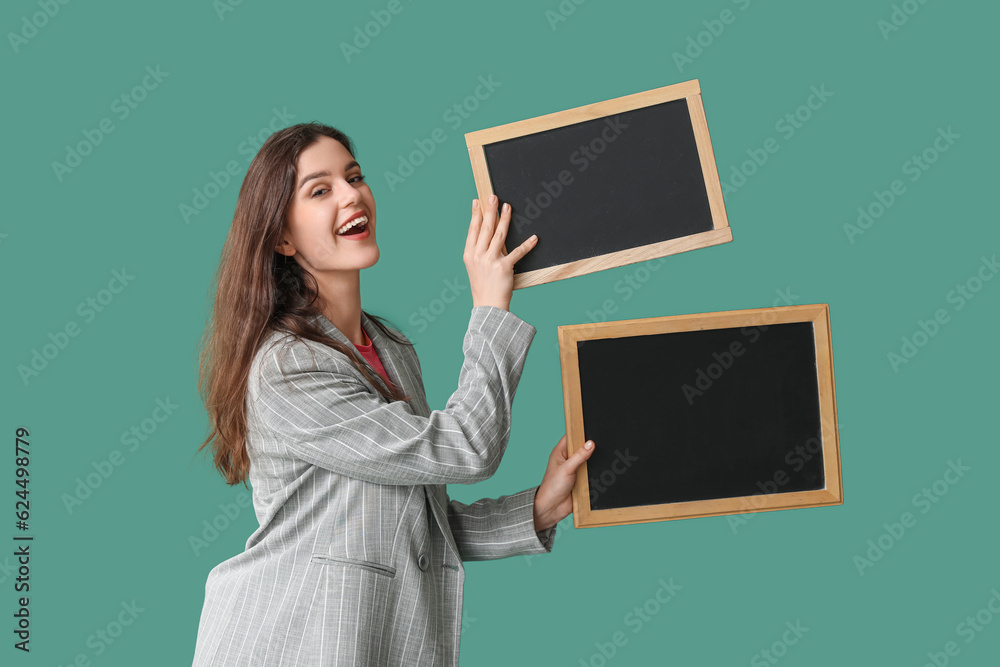 Female teacher with chalkboards on green background