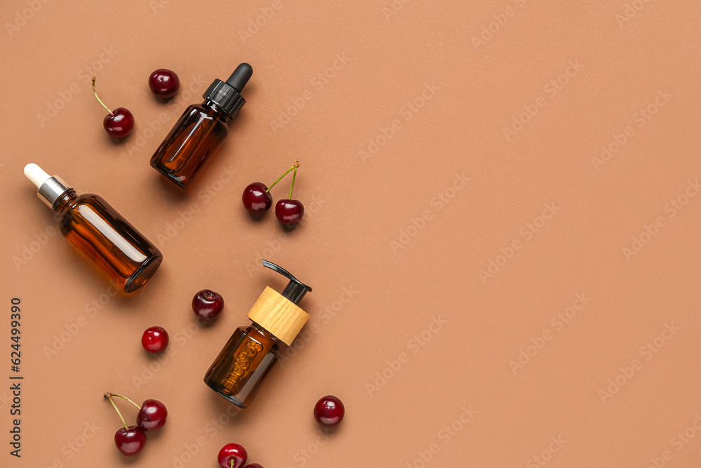 Composition with bottles of cosmetic products and sweet cherry on color background