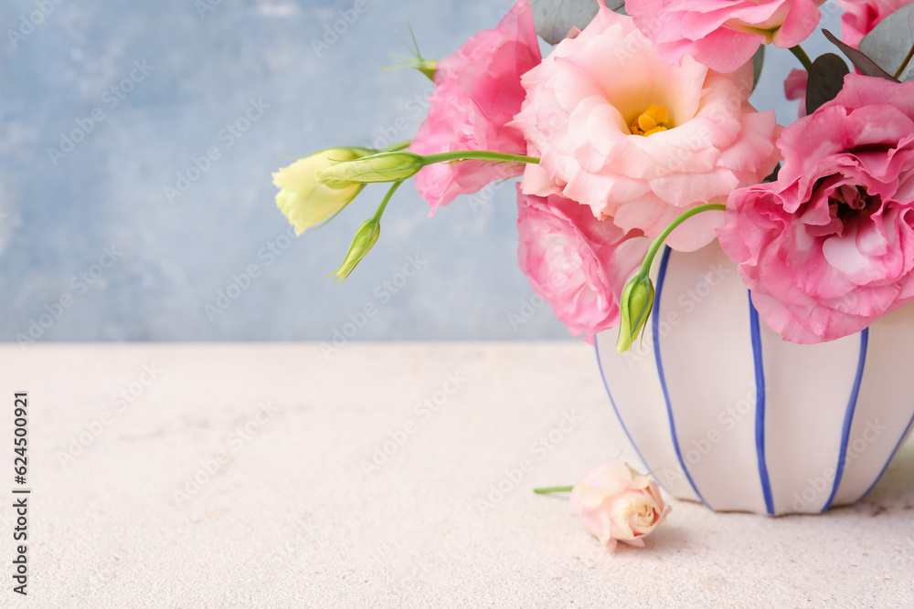 Vase with beautiful pink eustoma flowers on white table