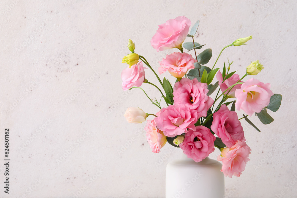 Vase with beautiful pink eustoma flowers and eucalyptus on white background