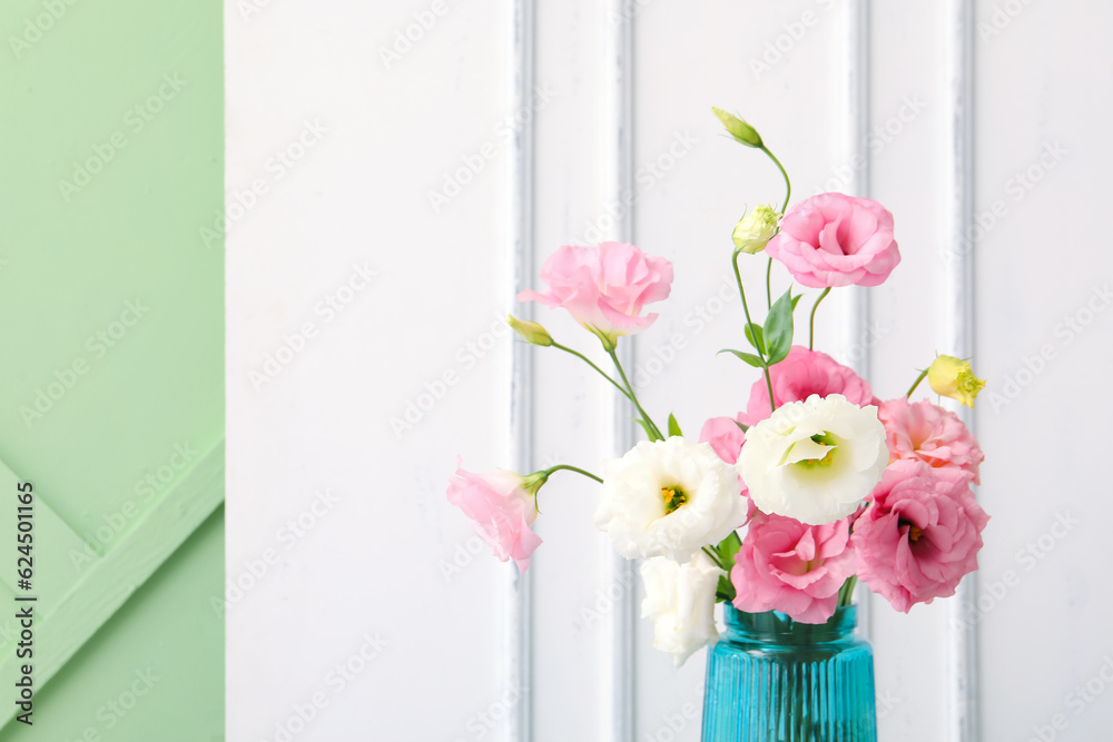 Vase with beautiful pink eustoma flowers on white background