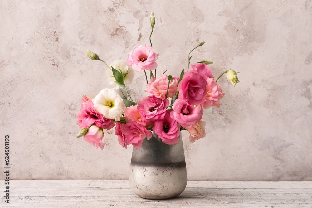 Vase with beautiful pink eustoma flowers on white wooden table