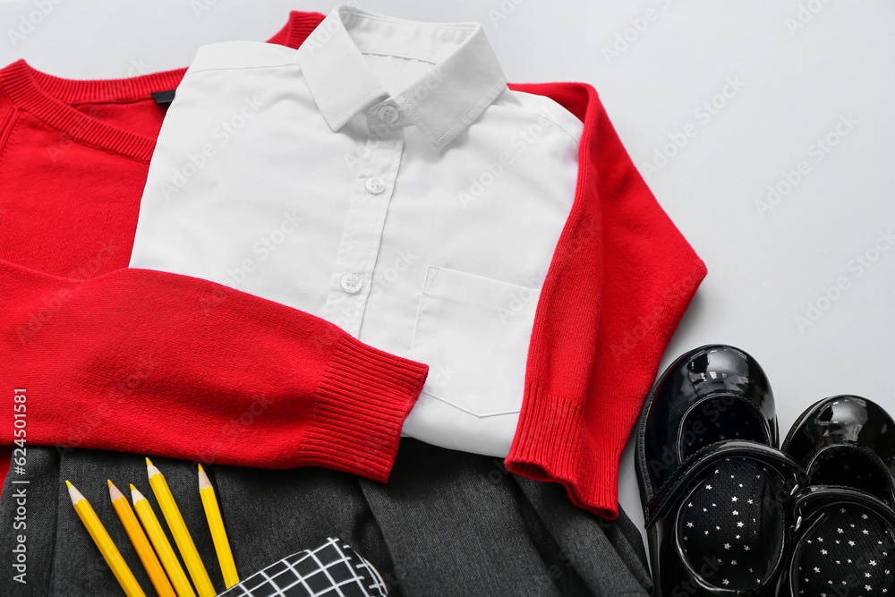 Stylish school uniform with different stationery on grey background