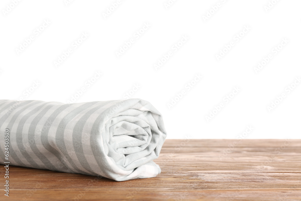 Rolled clean napkin on wooden table against white background