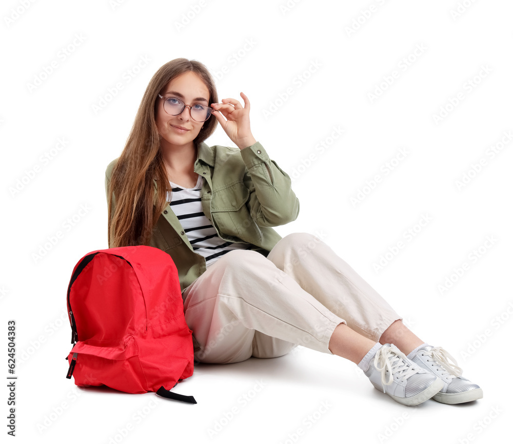 Female student with backpack sitting on white background