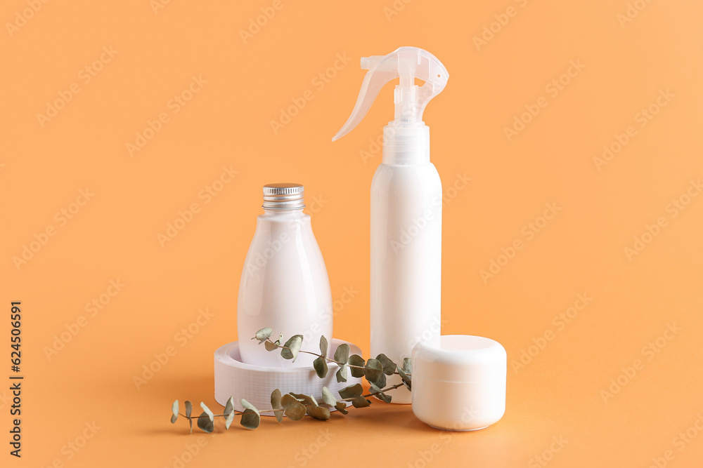 Set of cosmetic products and eucalyptus branches on color background