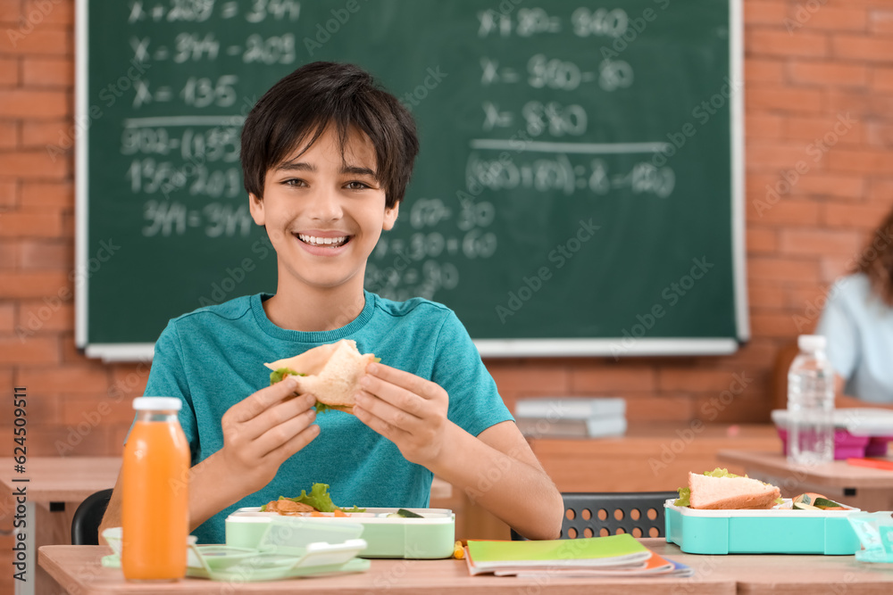 Little boy eating lunch in classroom