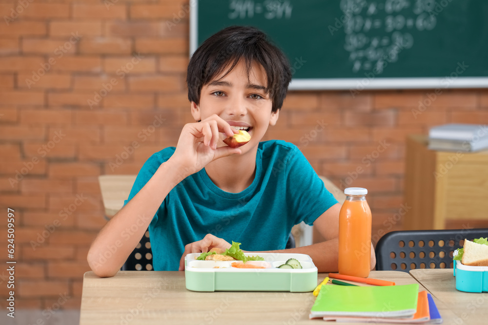 Little boy eating lunch in classroom