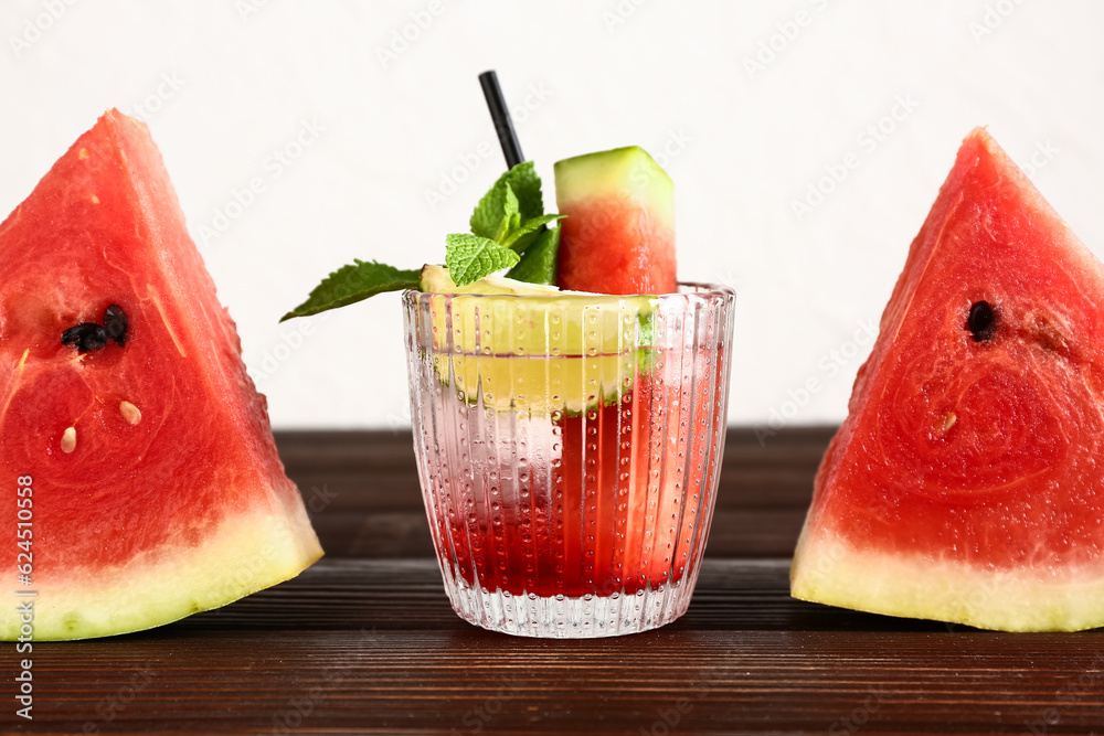 Glass of fresh watermelon lemonade with lime and mint on wooden table