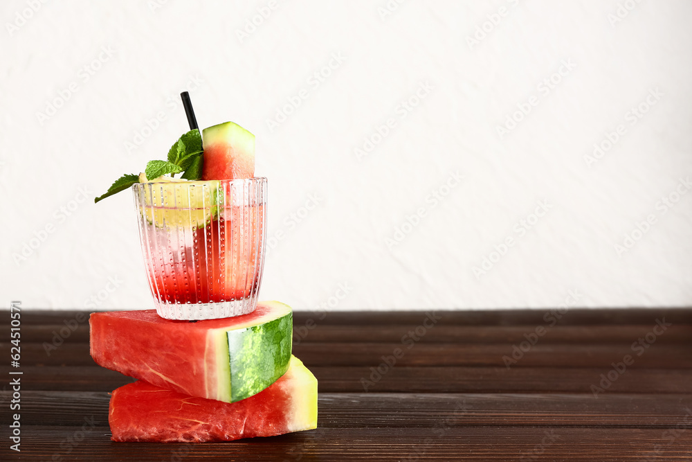 Glass of fresh watermelon lemonade with lime and mint on wooden table