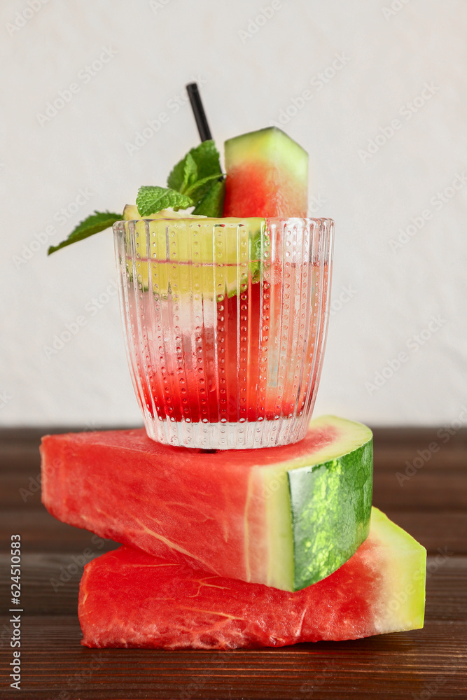 Glass of fresh watermelon lemonade with lime and mint on wooden table