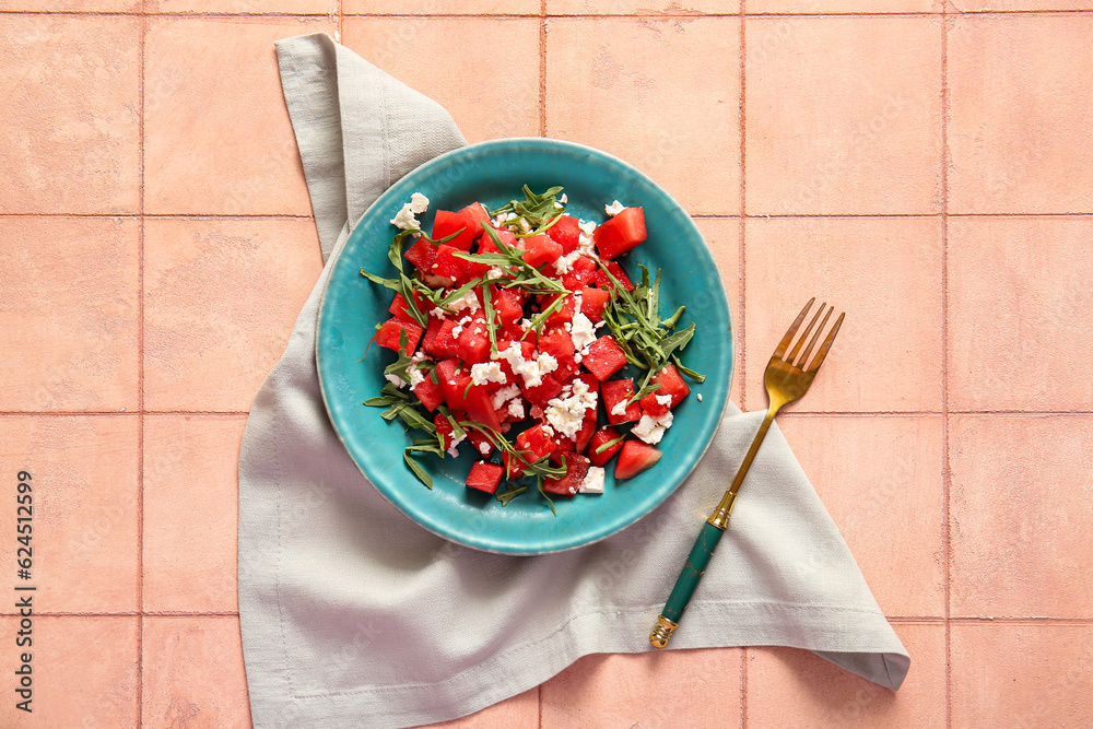 Plate of tasty watermelon salad on beige tile background