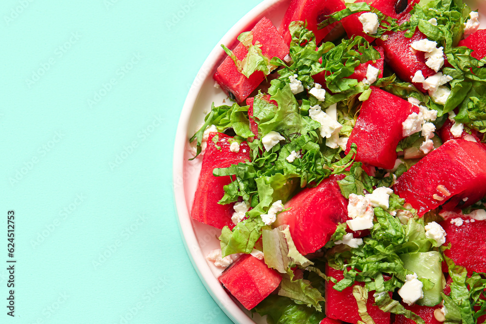 Plate of tasty watermelon salad on turquoise background