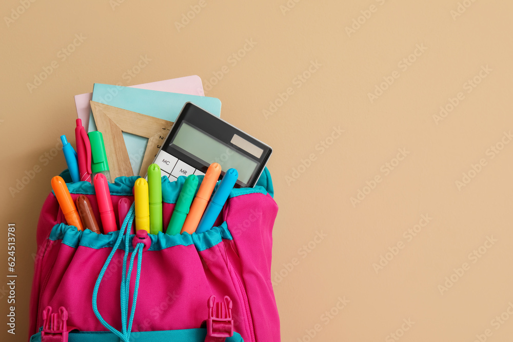 Colorful school backpack with different stationery on orange background