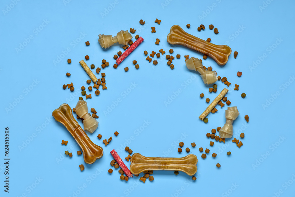 Frame made of different dog treats on color background