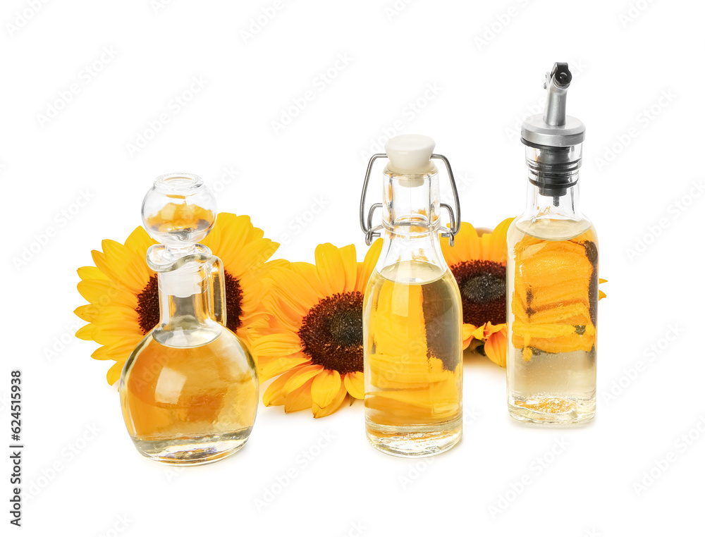 Bottles and decanter with sunflower oil on white background