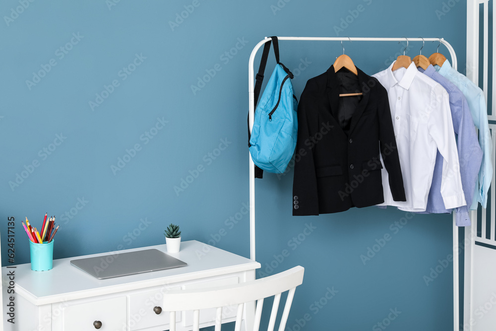 Stylish interior of childrens room with laptop and school uniform