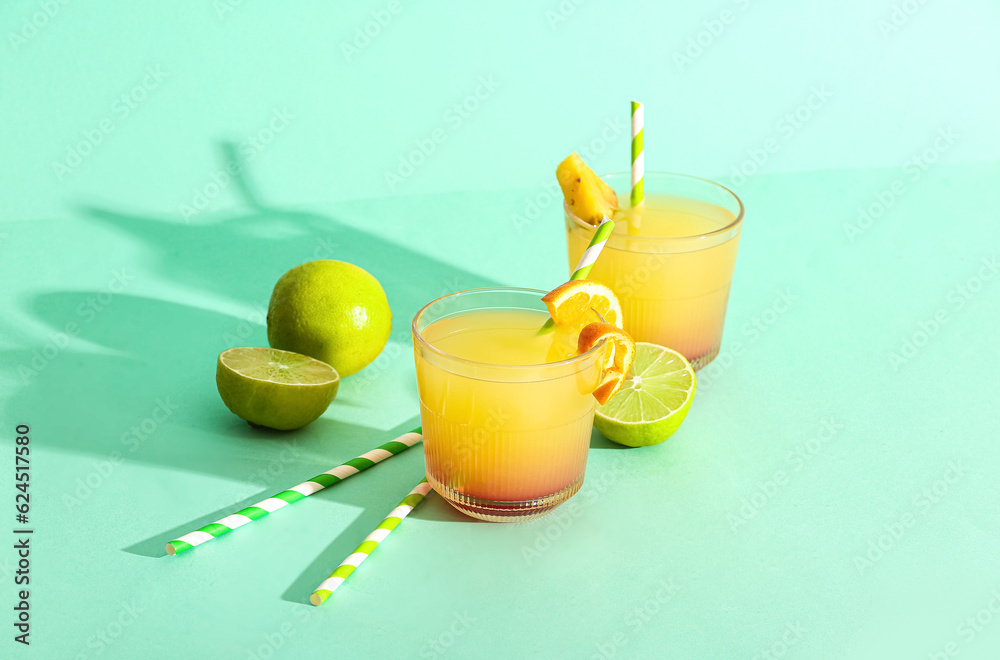 Glasses of tasty mai tai cocktail on green background