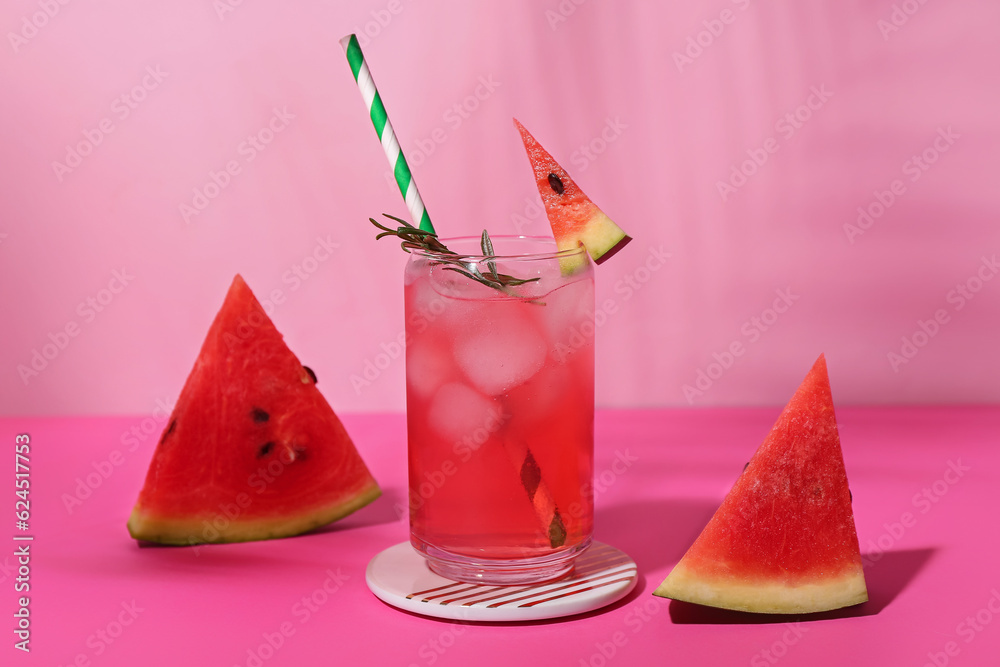 Glass of tasty watermelon cocktail on pink table near wall