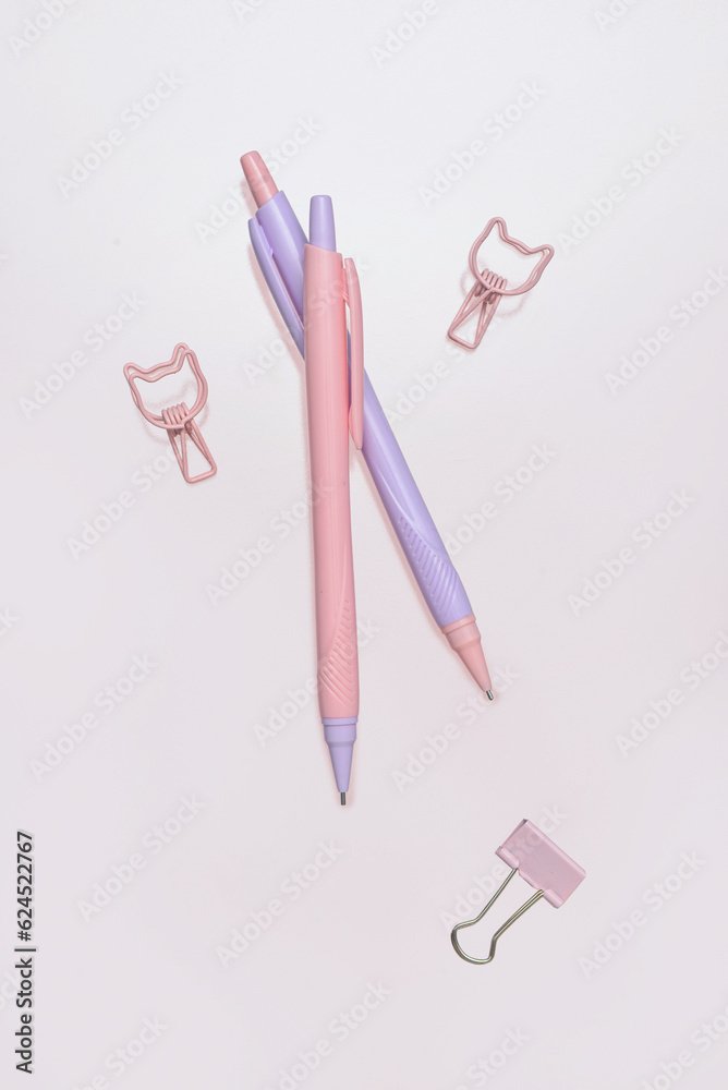 Pencils and paperclips on pink background