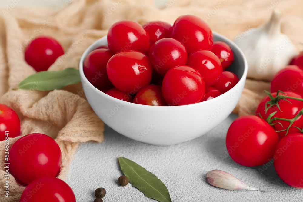 Bowl with canned tomatoes and garlic on white background