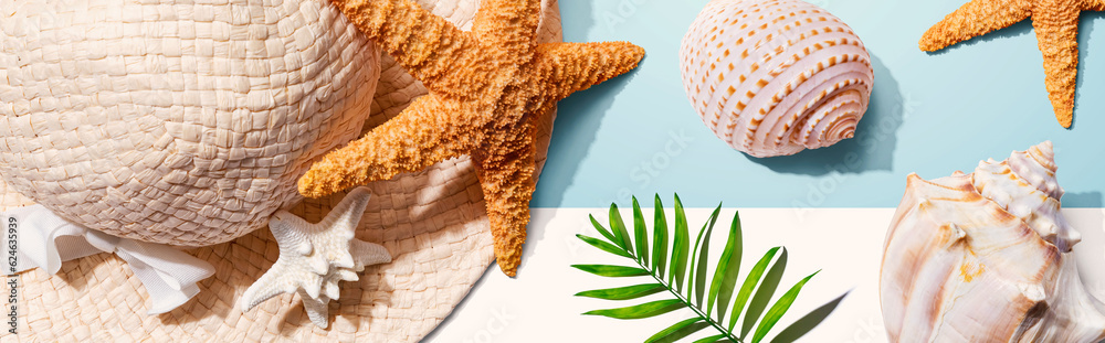 Summer concept with a straw hat and starfish overhead view - flat lay