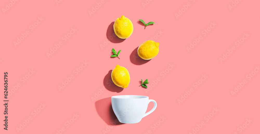 Fresh yellow lemons with tea cup overhead view - flat lay