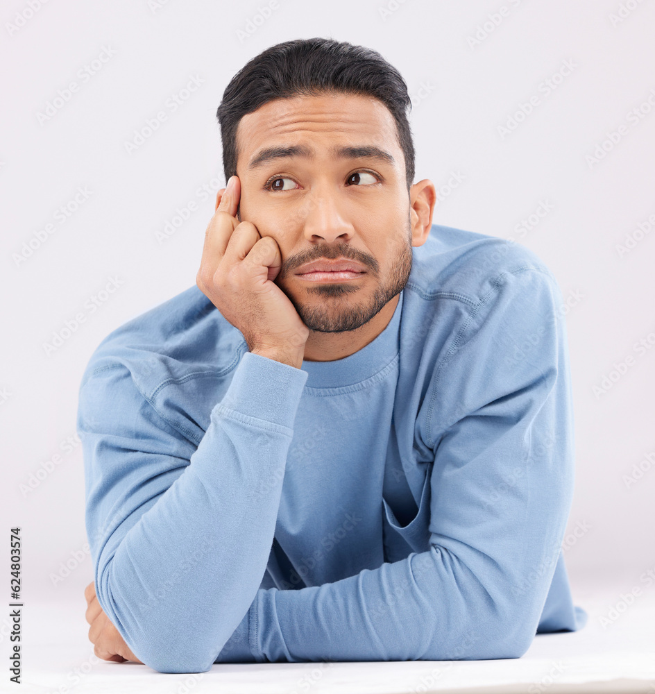 Thinking, remember and young man in a studio resting on his arms with a contemplating facial express