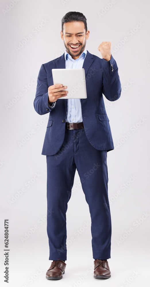 Happy businessman, tablet and fist pump for winning, promotion or bonus against a grey studio backgr