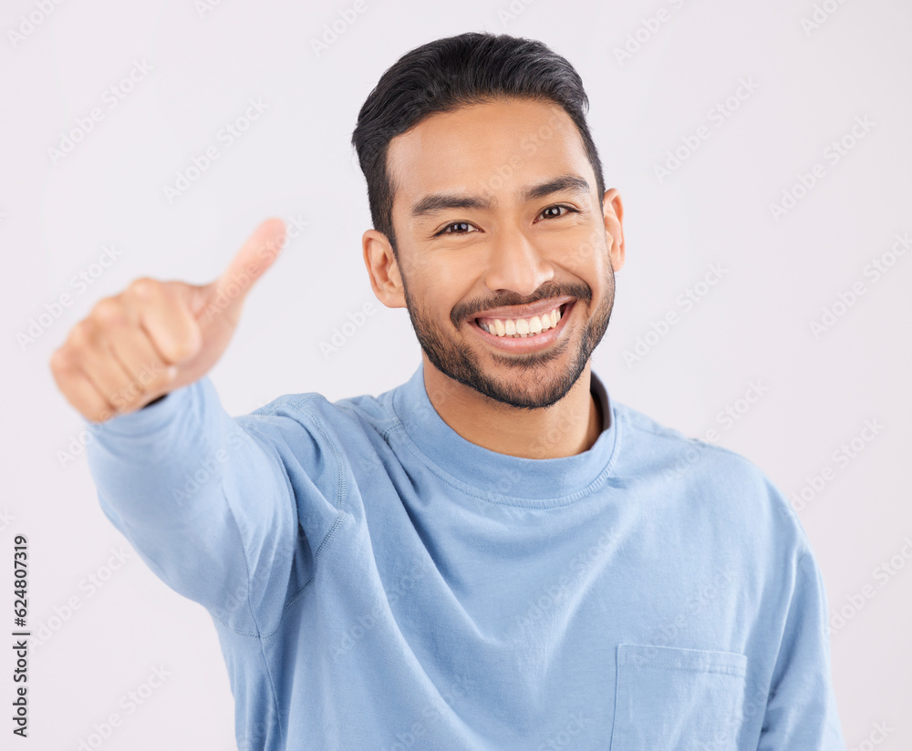 Portrait, smile and asian man in studio with thumbs up, hand or thank you sign on grey background. H