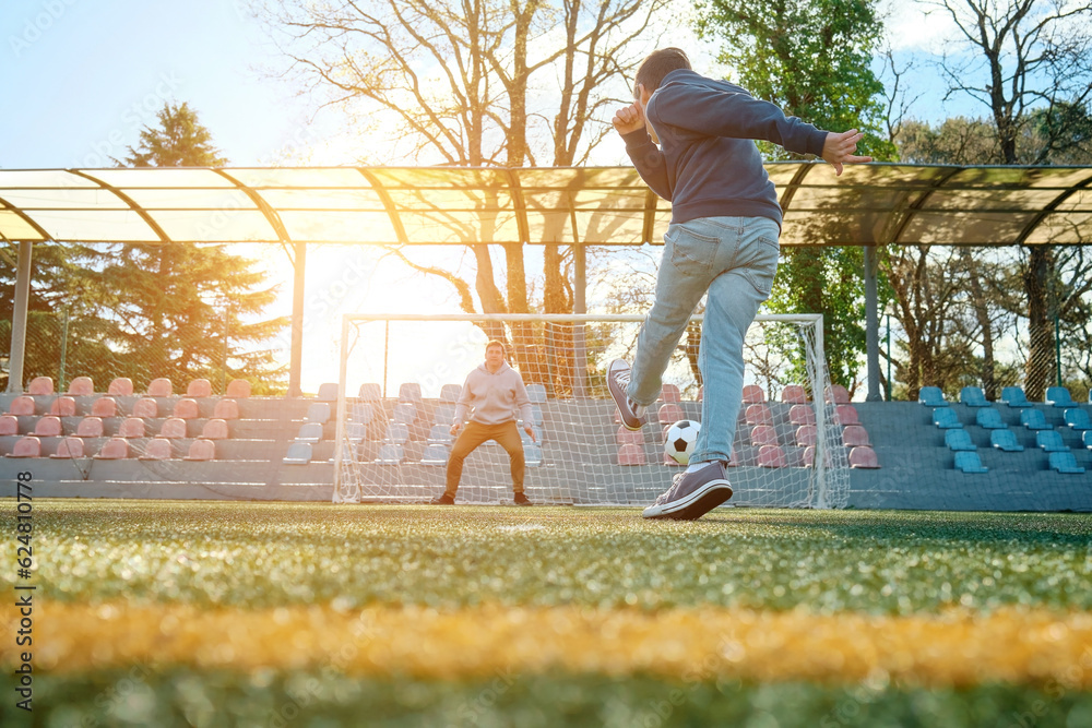 Happy family, Father and Son play football on stadium outdoors, bonding, fun, players in soccer in d