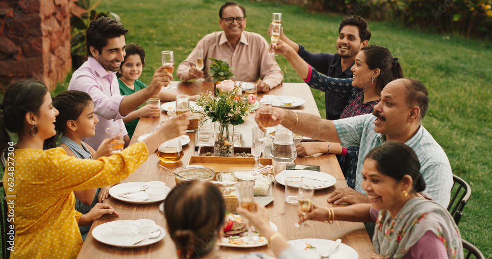 Happy Indian Family Celebrating: Group of People Gathered Together at the Table Raise Glasses To Mak