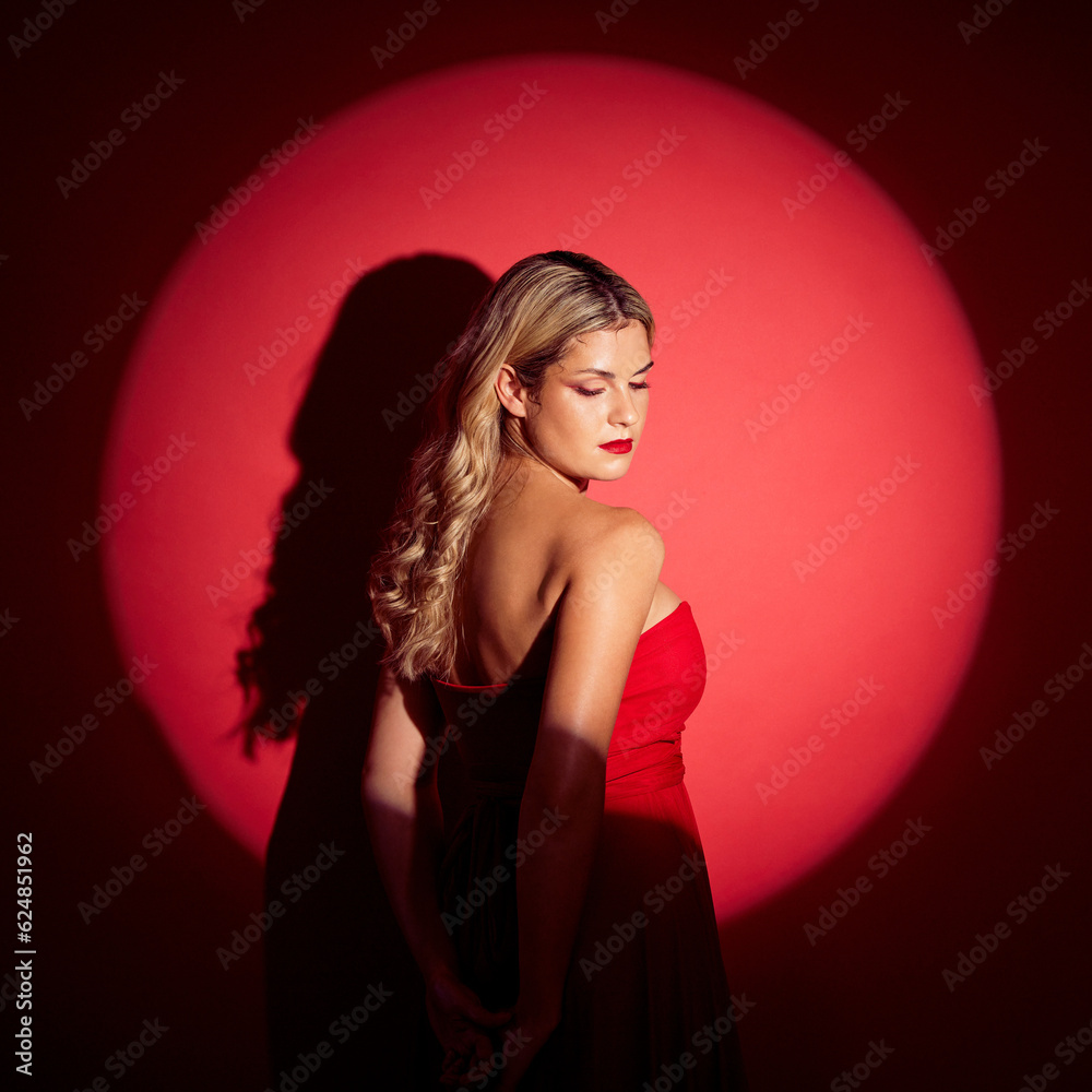 Beauty, spotlight and red with a model woman in studio on a dark background for classy elegance or s