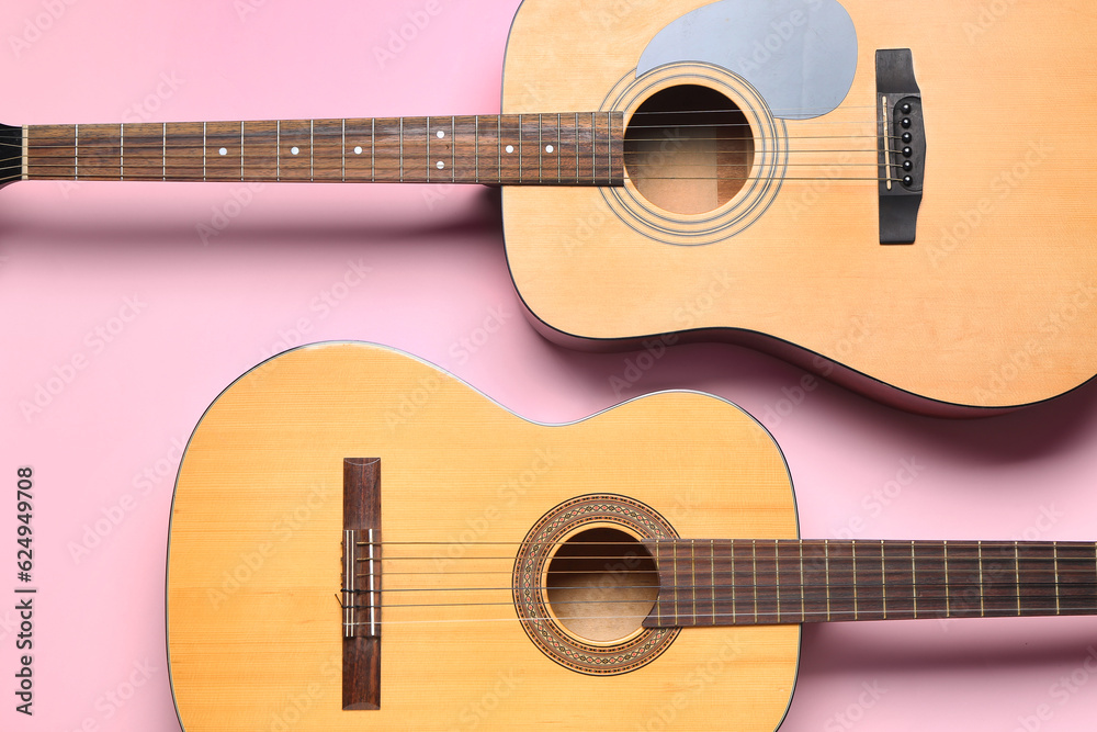 Acoustic guitars on color background, top view