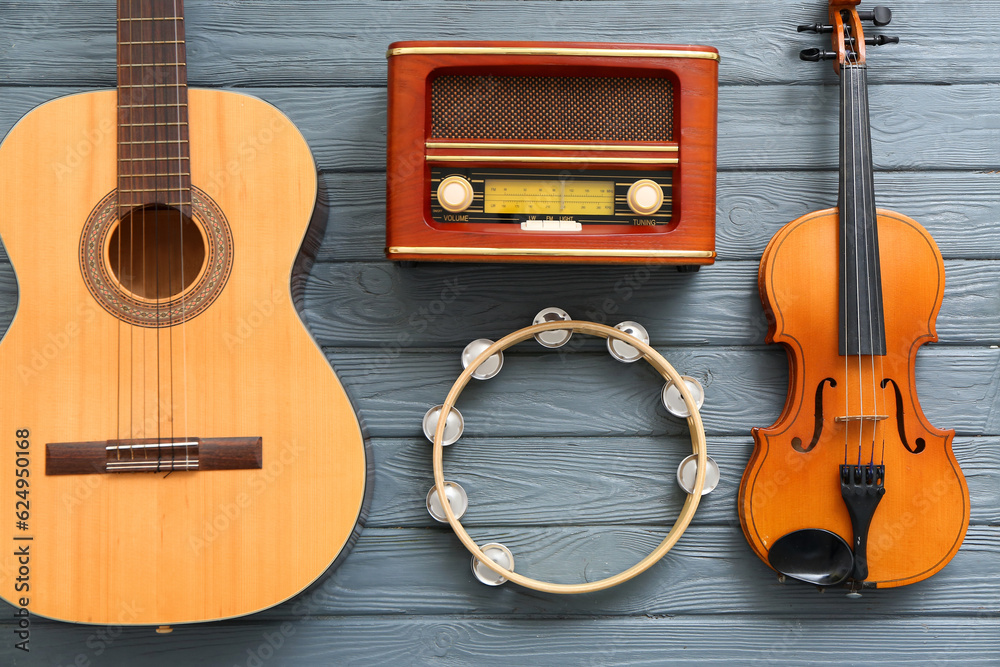 Different musical instruments and retro radio receiver on wooden background