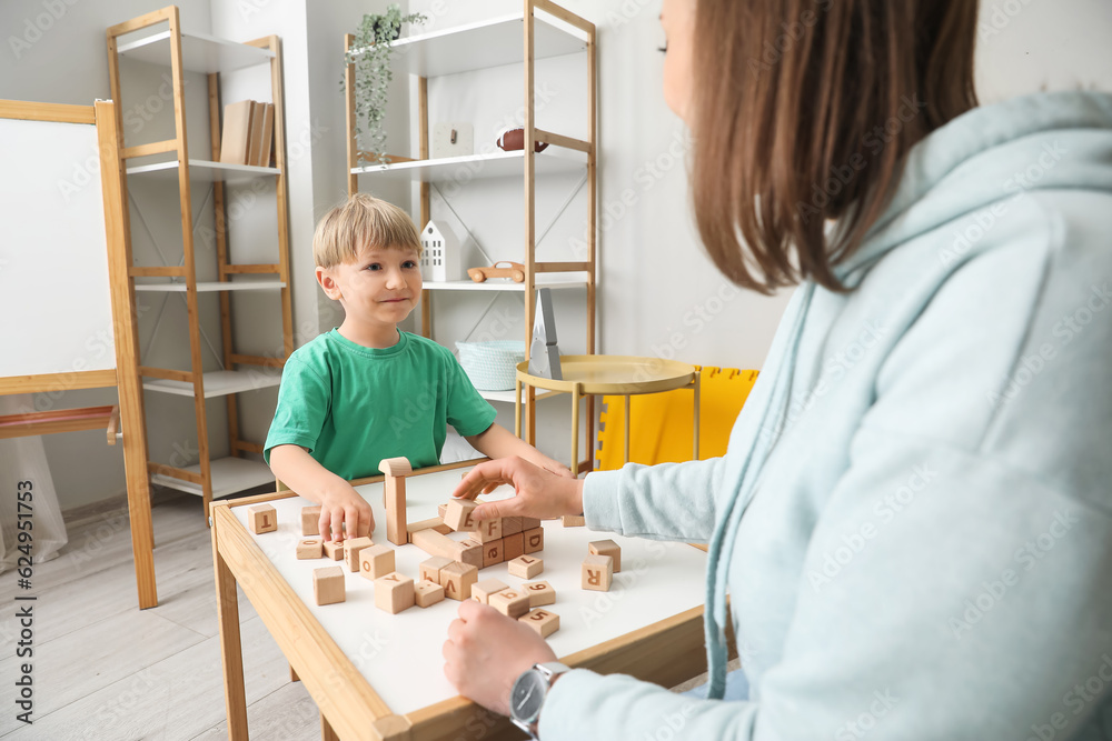 Little boy and nanny playing with cubes at home