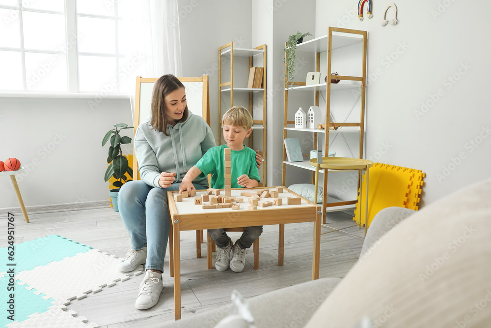 Little boy and nanny playing with cubes at home