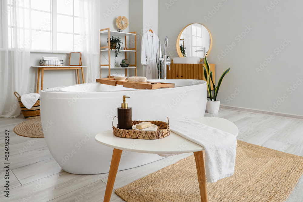 Basket with soap bar and dispenser on table in interior of bathroom