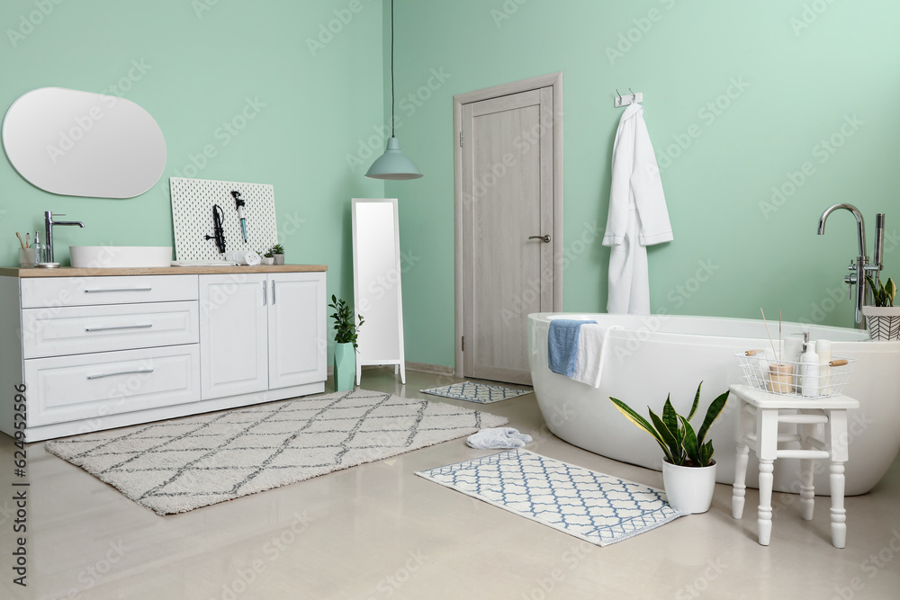 Interior of bathroom with bathtub, sink and mirror